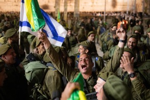 טירון לוחם בגולני גולני מריע שמח מחזיק דגל גולני בטקס טקס השבעה בכותל כותל
