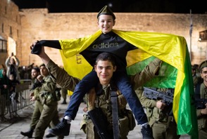 טירון לוחם בגולני גולני סוחב עם ילד על כתפיו עם דגל גולני בטקס טקס השבעה בכותל כותל