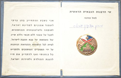 טירון ג'דעאן (גדעון) עבאס (לימים אל"ם) נשבע אמונים לצה"ל. מימין מדליון ובו בחלקו העליון מגן דוד על רקע כחול ולבן, מתחתיו סמל החרבות המוצלבות של יחידת המיעוטים, מתחתיו תבליט של נבי שועייב ומתחתיו המילים קבר יתרו בעברית ונבי שועייב בערבית (באדיבות אל"ם [במיל'] ג'דעאן עבאס)